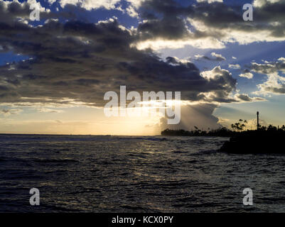 Sonnenuntergang durch die Wolken am Kekaha Hafen, auf der Südwestseite von Kauai, Hawaii, USA. Stockfoto