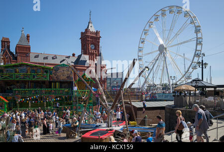 Pierhead Building und Riesenrad auf der ehemaligen Docks, mit Touristen im Vergnügungspark oin Roald Dahl Plas, Cardiff Bay, Cardiff, Großbritannien Stockfoto