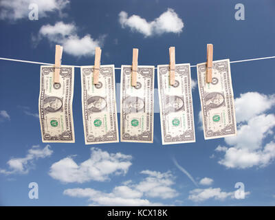 Ein dollarnoten hängt Wäsche mit Holz- Clips über blauen Himmel befestigt Stockfoto