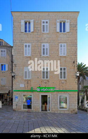 Ein Tourist mit einem Geldautomaten außerhalb eines Otp Banka in der Stadt Korcula, Insel Korcula, Kroatien, Dalmatien, Dalmatinischen Küste, Europa. Stockfoto