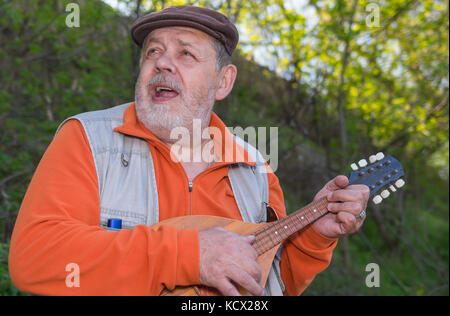 Outdoor Portrait von älteren Mann spielt Mandoline Singen Stockfoto