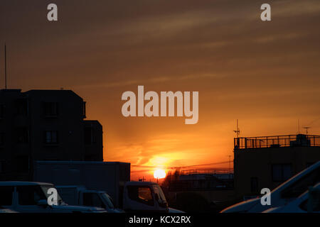 Ein Sonnenuntergang in einem Bereich von Tokyo mit weniger Wolkenkratzer. Sie sogar die Silhouetten der Berge in der Ferne sehen kann. Stockfoto