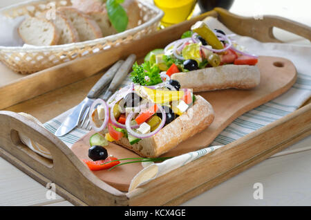 Köstlichen griechischen Bauernsalat mit Feta auf ciabatta Brot, serviert auf einem alten Holz- fach Stockfoto