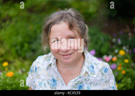 Portrait der kaukasischen Reife fröhliche reife Frau, die draußen in den Garten. Sie lächelt. Stockfoto