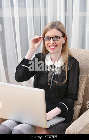 Junge Geschäftsfrau, die von zu Hause aus arbeiten am Laptop Stockfoto