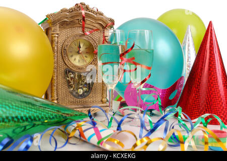 Tischuhr mit fast Zeit für neues Jahr, Luftschlangen, Luftballons, party Hüte und zwei Gläser Champagner Stockfoto