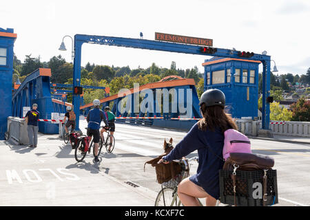 Seattle, Washington: Radfahrer und Fußgänger warten wie die Fremont Bridge öffnet sich für Boote zu übergeben. Die zweiflügelige Klappbrücke Seattle's fr verbindet Stockfoto