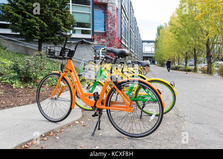 Seattle, Washington: Eine Vielzahl der Zyklus - teilen Sie Fahrräder bei Google seattle Waterside in Fremont geparkt. limebike (grün), ofo Bike (Gelb) und Spin Bike Stockfoto