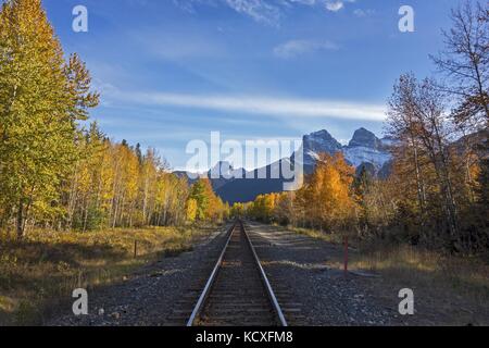 Canadian Pacific Railway Line Kreuzung in der Nähe von Canmore, Alberta Vorgebirge mit entfernten drei Schwestern Berg Querformat Stockfoto