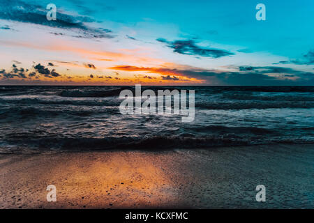 Blauer Himmel und orange Die reflektierenden Sonnenstrahlen das Meer bei Sonnenaufgang Stockfoto