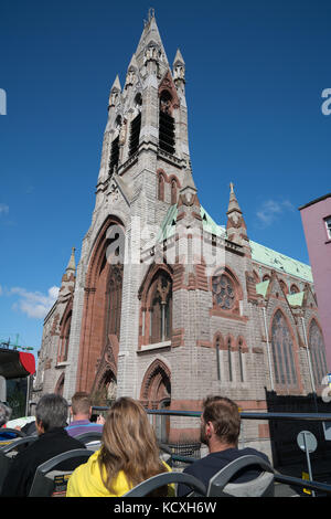 Dublin, Irland - 9 August, 2017; Touristen auf der Oberseite des Hop-on-Hop-off-Bus, City Tour Pass eine Kirche während den Touren durch die Stadt. Stockfoto