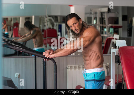 Schöne gut aussehende und attraktive junge Mann mit muskulösen Körper entspannend im Fitness-Studio Stockfoto