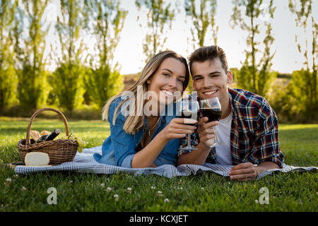 Schuss ein schönes Paar auf der Park ein Picknick und das Trinken von Wein Stockfoto