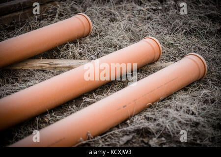 3 orange Rohre auf dem Boden Stockfoto