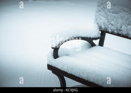 Bank im Park im Winter mit Schnee bedeckt Stockfoto