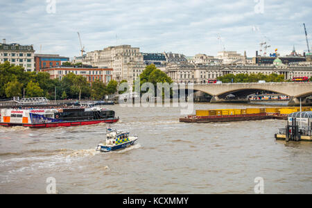 Die Marine Polizei, (Themse Polizei) Schnelle Reaktion Boot in der heißen Verfolgung eines beladenen Lastkahn bis Position der Themse in London, England, UK. Stockfoto