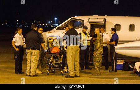 Ein Patient, der von den Virgin Islands nach dem Hurrikan Maria Okt. 2 evakuiert wurde, macht sich auf den Weg zu einem wartenden Rettungswagen nach durch medizinisches Personal an der Columbia Metropolitan Airport in Columbia, S.C. Der Kontaktstelle Columbia Team ausgewertet werden, war verantwortlich für die Aufnahme von Patienten in die Folgen des Hurrikans Maria evakuiert auf Flügen aus Puerto Rico und die U.S. Virgin Islands, die Bewertung der Patienten, und dann Sie mit Sorgfalt an einem lokalen Krankenhaus. FCC-Columbia, ein Team unter der Leitung von US-Armee Reservisten, war der erste Verteidigungsministerium Team ac. Stockfoto