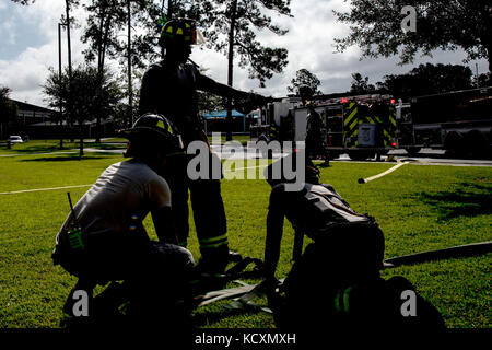 Feuerwehrmänner vom 23 d Bauingenieur Squadron (CES) vorbereiten, ein Schlauch während einer strukturellen Übung, Okt. 5, 2017 bei Moody Air Force Base, Ga. Die 23d CES Rolle die Ausbildung Bereitschaft für Brandfälle auf Basis geschehen könnte, um sicherzustellen, dass statt. (U.S. Air Force Foto von Airman Eugene Oliver) Stockfoto