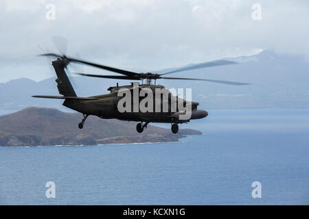 Ein U.S. Army UH-60 Black Hawk Helikopter mit Joint Task Force - Leeward Inseln fliegt über das Karibische Meer, da es Ansätze Pointe-à-Pitre Flughafen Pointe-à-Pitre, Guadeloupe, 4. Oktober 2017. Auf Antrag der US-Agentur für Internationale Entwicklung, JTF-LI bereitgestellt hat, Flugzeuge und Service Mitglieder in der Bereitstellung von Hilfsgütern zu Dominica in der Nachmahd des Hurrikans Maria zu unterstützen. Die Task Force ist in den USA eine militärische Einheit, die aus Marinen, Soldaten, Matrosen und Fliegern und stellt erste Reaktion US Southern Command zu den Hurrikanen, dass die ea ausgewirkt hat. Stockfoto