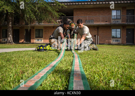 Feuerwehrmänner vom 23 d Bauingenieur Squadron (CES) rollen Sie einen Schlauch während einer strukturellen Übung, Okt. 5, 2017 bei Moody Air Force Base, Ga. Die 23d CES hielt die Ausbildung Bereitschaft für Brandfälle auf Basis geschehen könnte, zu gewährleisten. (U.S. Air Force Foto von Airman Eugene Oliver) Stockfoto