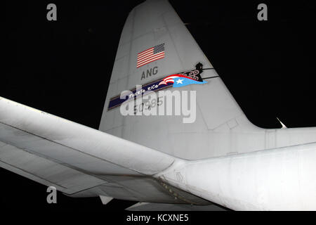 Dunkelheit fiel auf ein Puerto Rico Air National Guard C-130 Hercules als eine Lieferung von Hilfsgütern, die von mehreren Gruppen in Washington D.C. gespendet, Muniz Air National Guard Base, Okt. 5, 2017 entladen wurde. Die 156 Airlift Wing, Puerto Rico Air National Guard, hat zahlreiche Luftbrücke Missionen zur Unterstützung der Hurrikan Maria Entlastung Bemühung geflogen. Der Hurrikan Puerto Rico an Sept. 20. (U.S. Air National Guard Foto von Tech. Sgt. Dan Heaton) Stockfoto