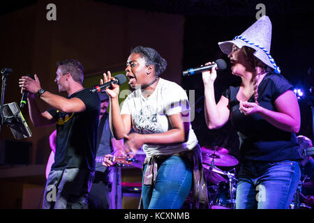 Sänger der U.S. Air Force Central Command Band begleiten andere Coalition-Mitglieder auf der Bühne bei einer Aufführung von „Sweet Home Alabama“ während einer Oktoberfestfeier am 24. September 2017 in Südwestasien. Das USAFCENT-Band, Touch N’ Go, reist zu einer Reihe von Installationen zur Unterstützung des Betriebs inhärenten Auflösung. (USA Luftwaffe Foto von Senior Airman Joshua Kleinholz) Stockfoto