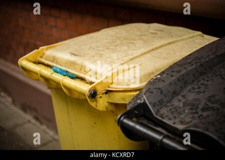 Gelb und Schwarz Abfalleimer Mülleimer auf dem Bürgersteig Stockfoto