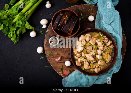 Zartes Hähnchenbrustfilet Stücke mit Pilzen und Sellerie geschmort in helles Bier. Flach. top View Stockfoto