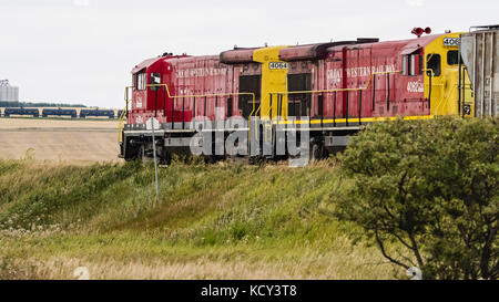 Assiniboia, Saskatchewan, Kanada. September 2017. Ein Güterzug der Great Western Railway (GW Rail) fährt entlang der Gleise in der Nähe von Assiniboia, Saskatchewan. Die Kurzstrecke verkehrt in Southwest Saskatchewan auf Gleisen, die einst der Canadian Pacific Railway gehörten. Im Hintergrund stehen Tankwagen, die auf einem Anschlussgleis geparkt sind. Quelle: Bayne Stanley/ZUMA Wire/Alamy Live News Stockfoto