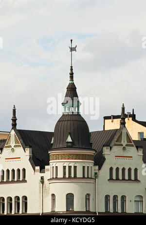 Fragment eines antiken Gebäudes mit einem Revolver und einer Wetterfahne in Helsinki Stockfoto