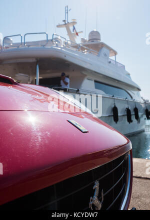 Roten Ferrari vor Yacht an Port Vauban, Antibes, Cote d'Azur, Provence-Alpes-Cote d'Azur, Frankreich geparkt. Stockfoto