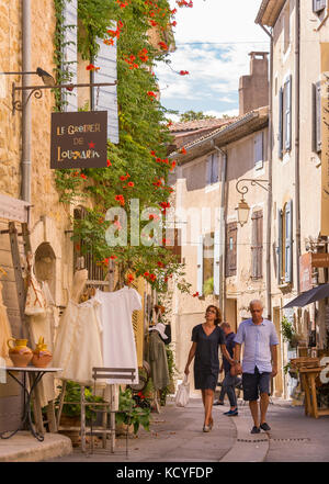 In Lourmarin, Provence, Frankreich - Paar Spaziergänge durch Geschäfte in Lourmarin, einem Dorf in der Landschaft von Luberon, Region Vaucluse. Stockfoto