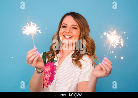 Portrait eines glücklichen Frau mit bengalischen Lichter über blauen Hintergrund. Weihnachten, Feste und Feiertage Konzept Stockfoto