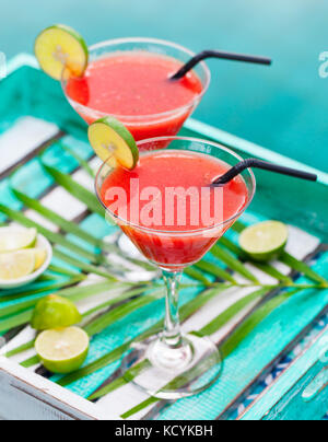 Strawberry Margarita Cocktail auf bunten Holz- Hintergrund mit Palm Leaf. Stockfoto