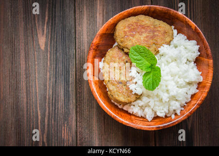 Schnitzel mit Reis in eine Schüssel geben. Stockfoto