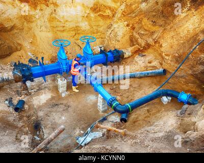 Technischer Experte u-Schieber auf 500 mm Wasser trinken Rohre verbunden mit neuen schwarzen Exzenter Verschluss in alte Pipeline System. Stockfoto