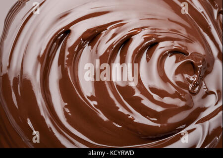 Geschmolzene Schokolade swirl Hintergrund. Glänzend splash von Schokolade Textur. Stockfoto