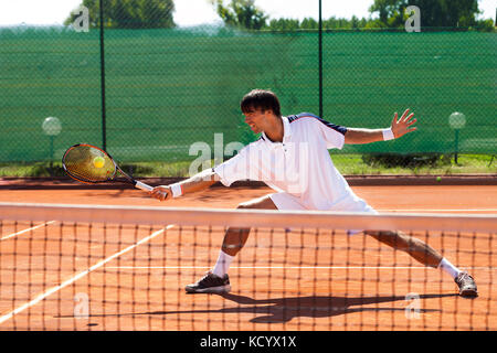 Hübscher junger Mann Tennis spielen Stockfoto