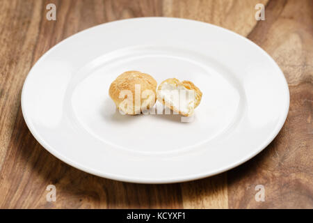 Profiteroles auf Platte Nahaufnahme einer in Scheiben geschnitten Stockfoto