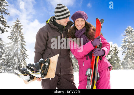 Paar stehend auf einem schneebedeckten Berg in Ski Outfit Stockfoto