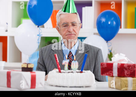 Älterer Mann an seinem Geburtstag Kuchen für 70. Geburtstag suchen Stockfoto