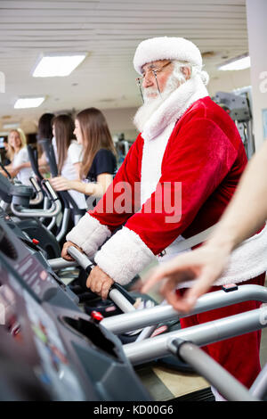 Santa claus Training auf dem Laufband im Fitnessstudio Stockfoto