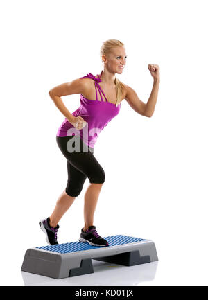 Schöne blonde junge Frau mit Step Aerobic Übung Stockfoto