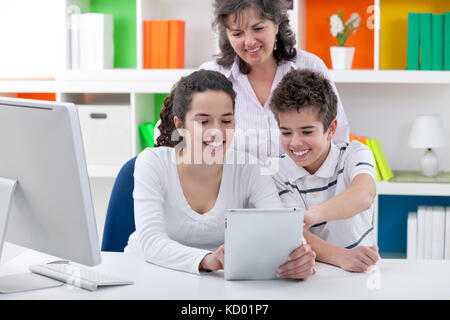 Mutter mit ihren Kindern geniessen mit digitalen Tablet Stockfoto