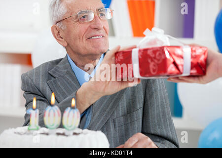 Ältere Menschen erhalten Geschenk zum Geburtstag Stockfoto