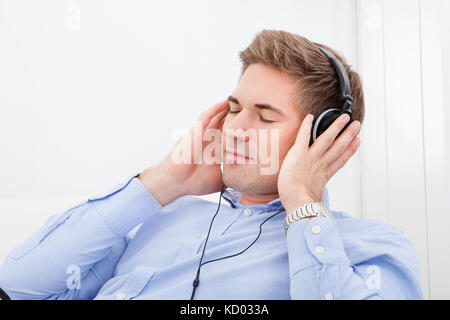 Glücklich Jüngling Musikhören mit Kopfhörer Stockfoto