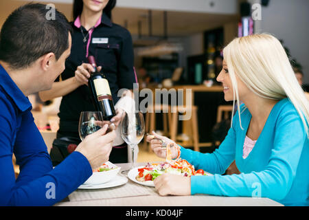 Junges Paar mit Mittagessen im Restaurant und Auswahl von Wein Stockfoto