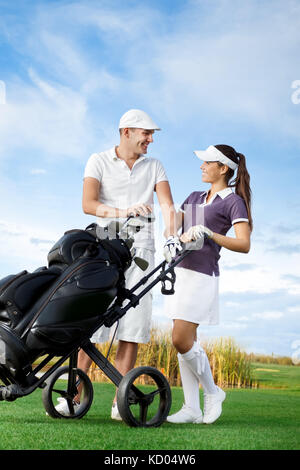 Paar Golf spielen an einem sonnigen Tag an jedem anderen suchen und Lachen Stockfoto