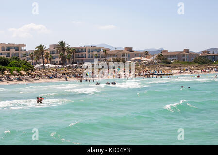 Touristen im Urlaub an der Playa de Muro in der Bucht von Alcudia, Mallorca, Balearen Inseln Stockfoto