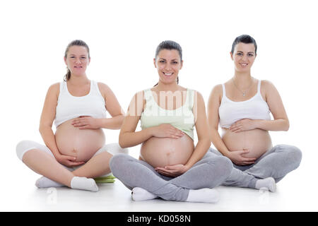 Gruppe von lächelnden schwangere Frauen tun Schwangerschaftsyoga Stockfoto